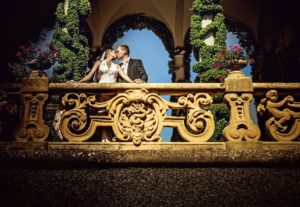 couple kissing on balcony of Villa Balbianello in Lake Como