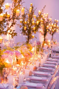 candelabras covered in greenery and candles
