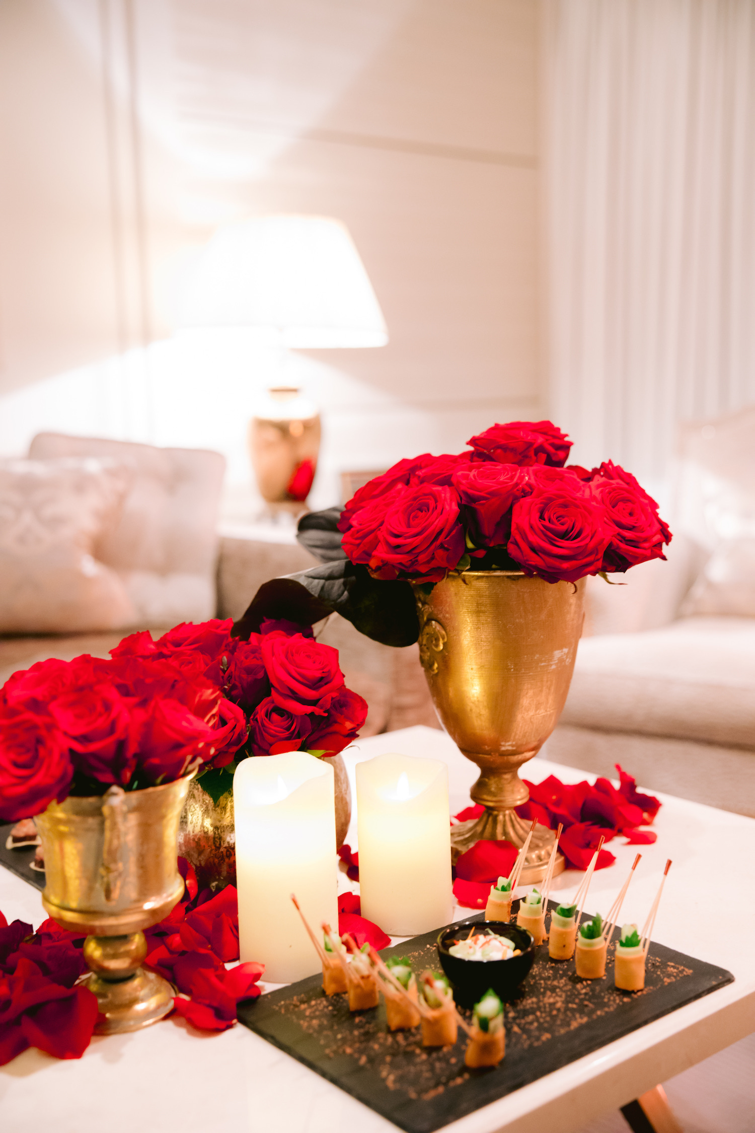 red rose arrangements in gold vessels