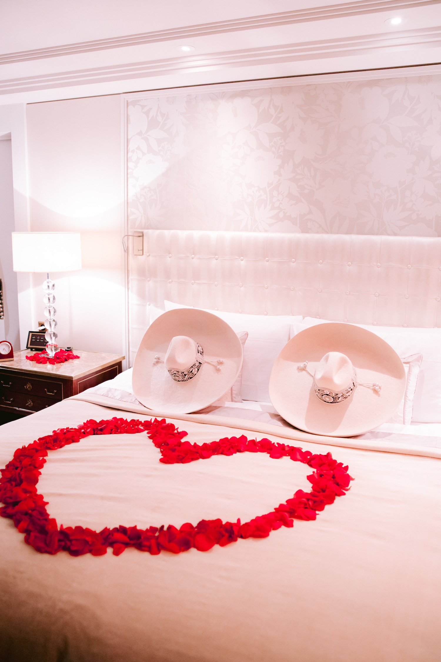 bed with sombreros and red rose petals